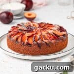 Plum Cake on a white plate topped with icing sugar.