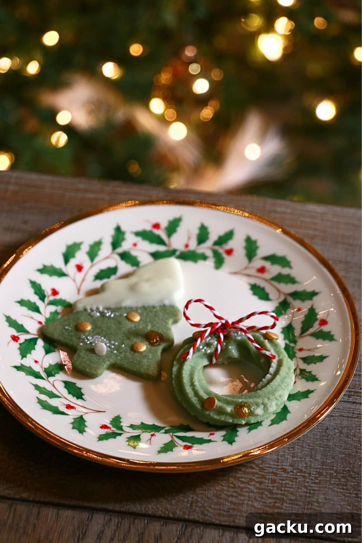 a christmas tree cookie and wreath cookie on a plate