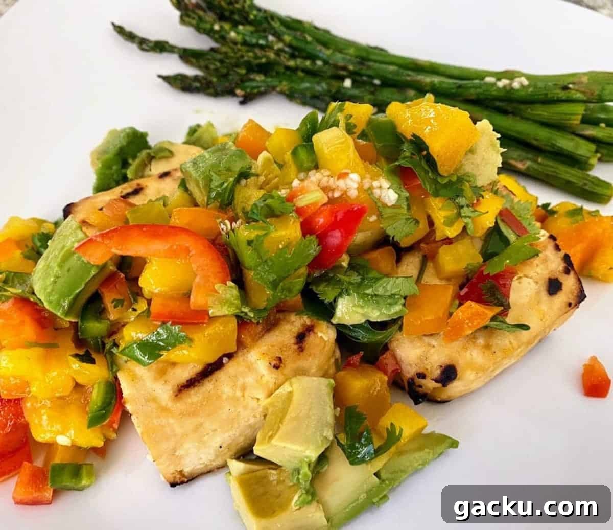 Grilled tofu recipe with mango salsa and asparagus on a plate. 