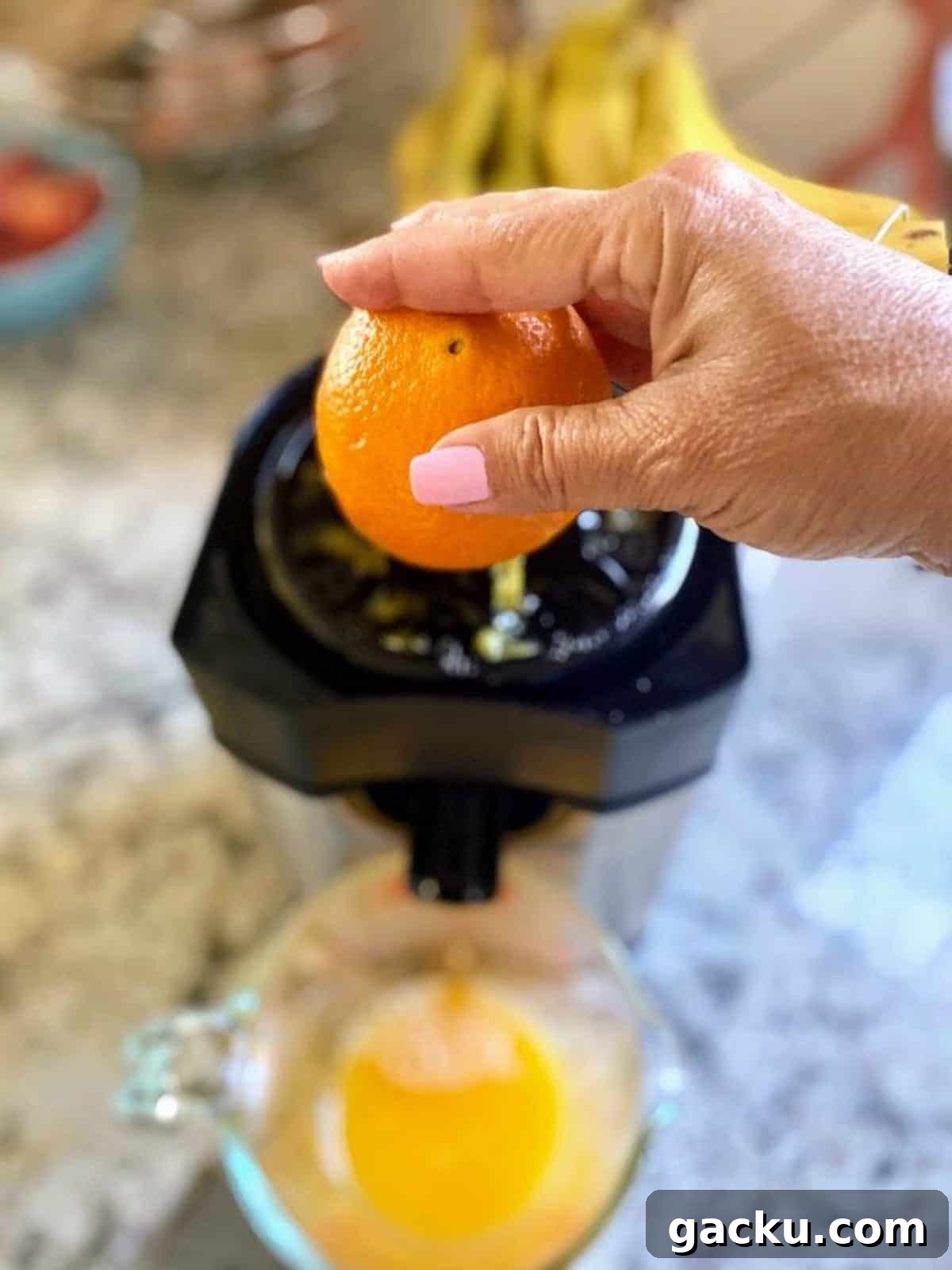 Squeezing oranges using a juicer. 