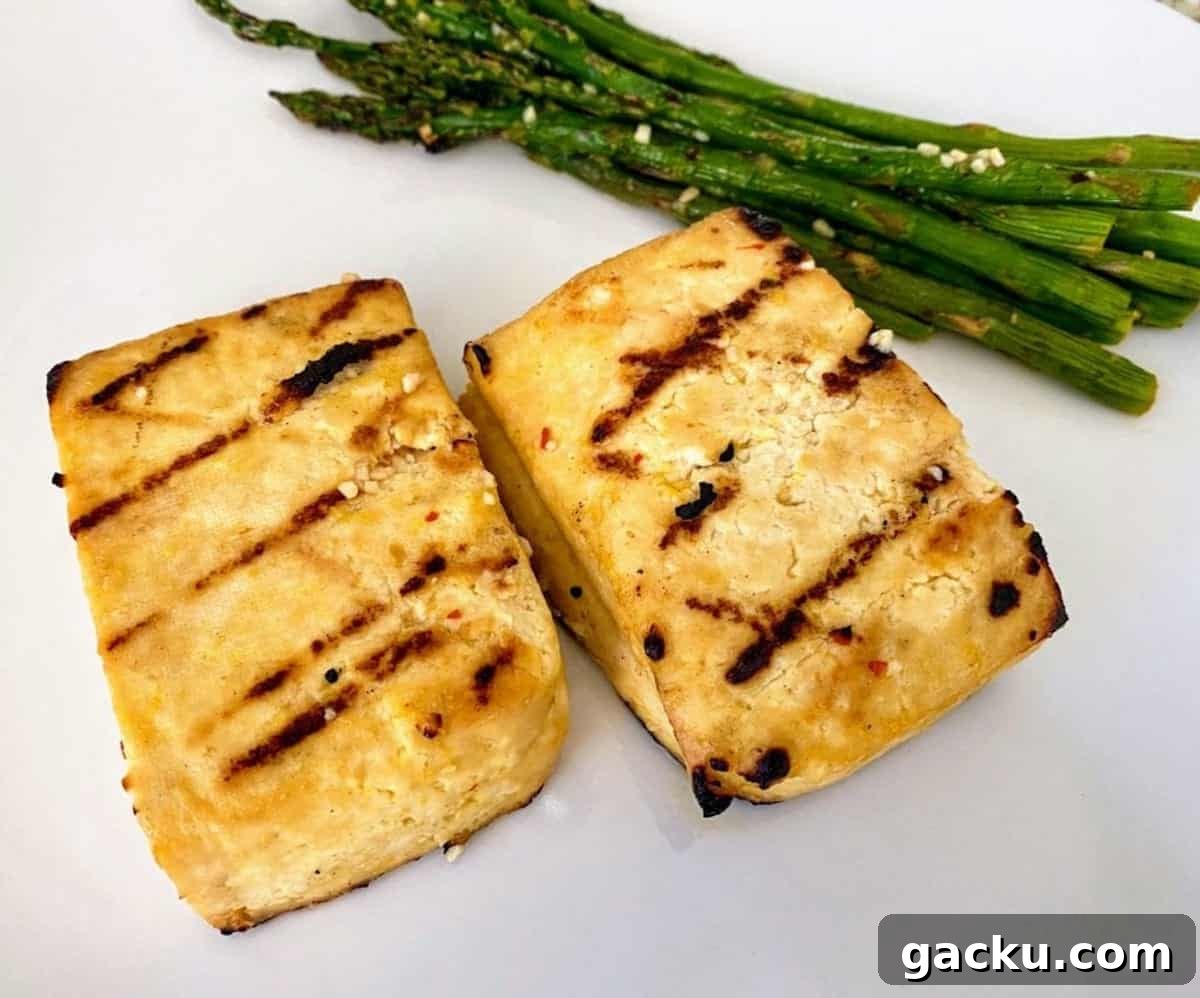 Grilled tofu and asparagus on a plate. 