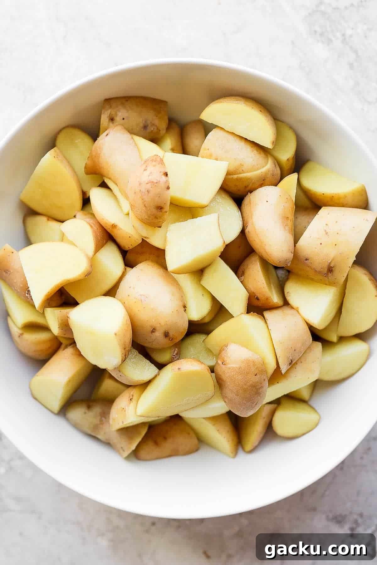 Smoked Potatoes Recipe: Crispy, Smoky Sides from the Grill 3 Cubed potatoes in a large white bowl.