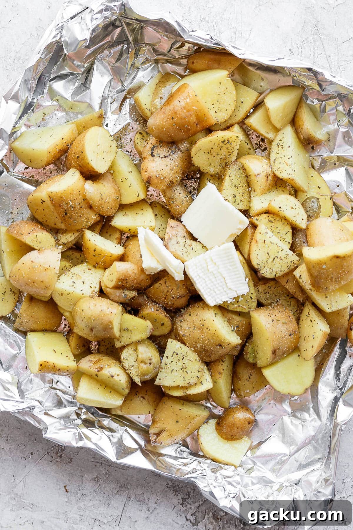 Smoked Potatoes Recipe: Crispy, Smoky Sides from the Grill 6 Seasoned potatoes in an aluminum foil boat with a dollop of butter on top before going on the smoker.
