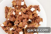 A white dinner plate with golden graham s'more bars stacked on top of each other.