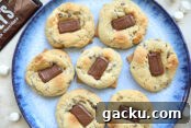 A plate of S'more Chocolate Cookies with a Hershey bar in the upper left corner and mini marshmallows scattered around the plate.