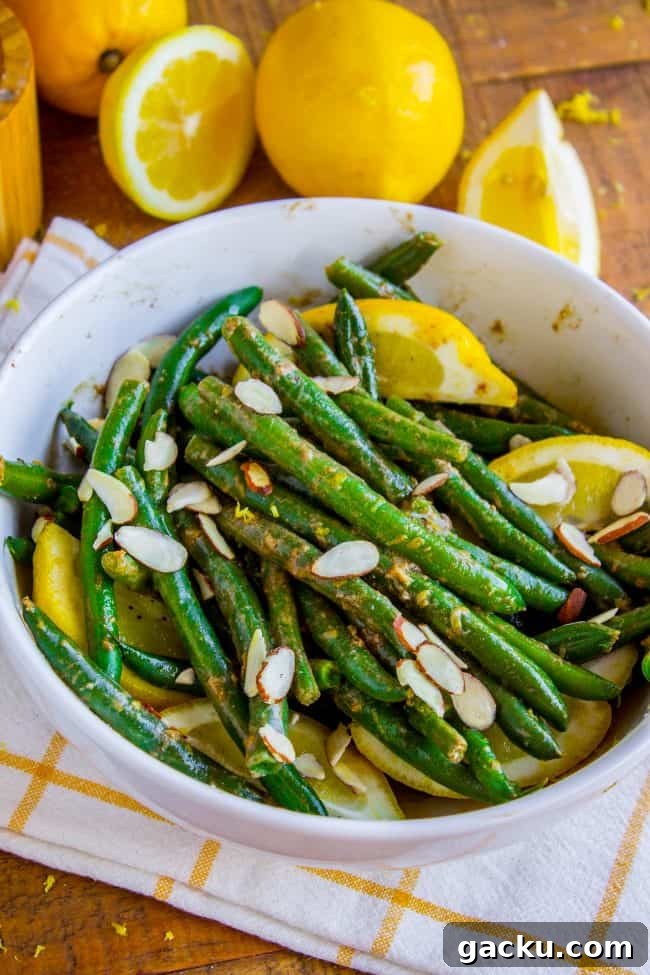 Lemon Dijon Green Beans Almondine green beans with lemons and almonds in a pan.