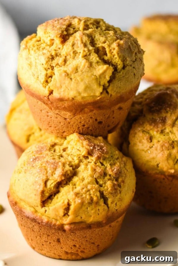 Pumpkin jumbo muffins stacked on a plate.