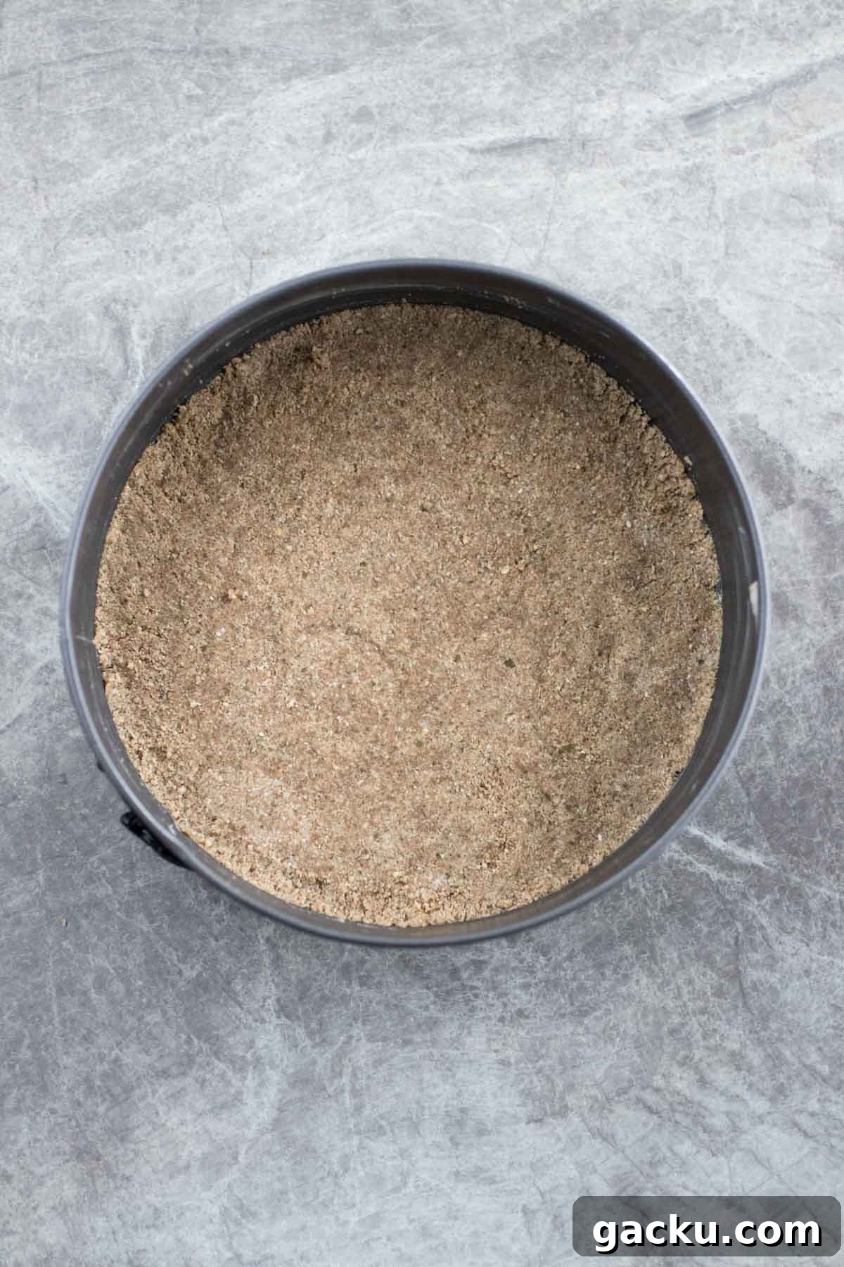 Packing the oatmeal crust into a springform pan.