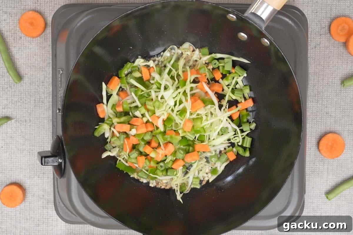 Vegetables added to the wok.