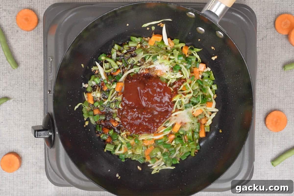 Schezwan sauce, vinegar, soy sauce, ketchup, salt and MSG added to the wok.