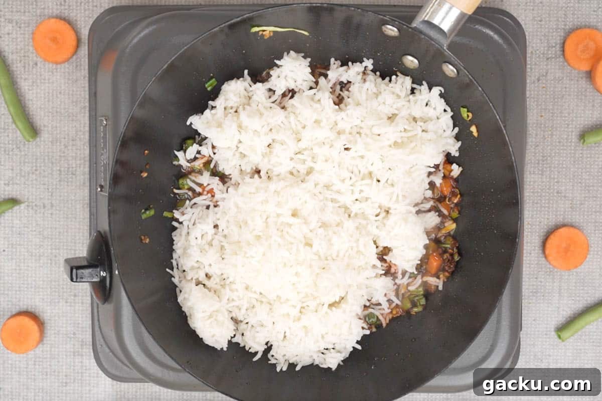Cooked rice added to the wok.