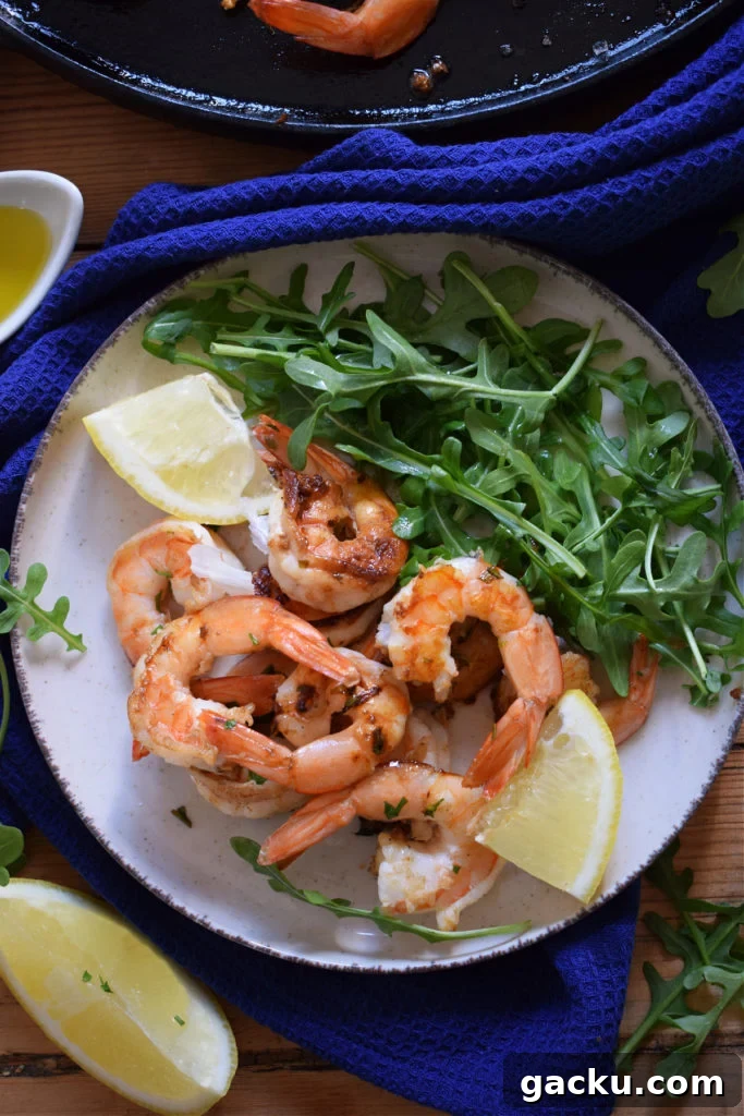 Zesty Lemon Skillet Shrimp Recipe — Quick Pan-Seared Shrimp 2 lemon shrimp on a plate with a salad.