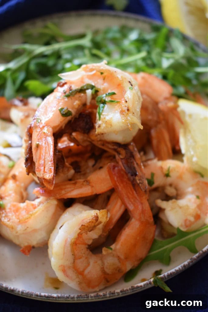 Zesty Lemon Skillet Shrimp Recipe — Quick Pan-Seared Shrimp 3 a pile of zesty lemon shrimp on a plate.