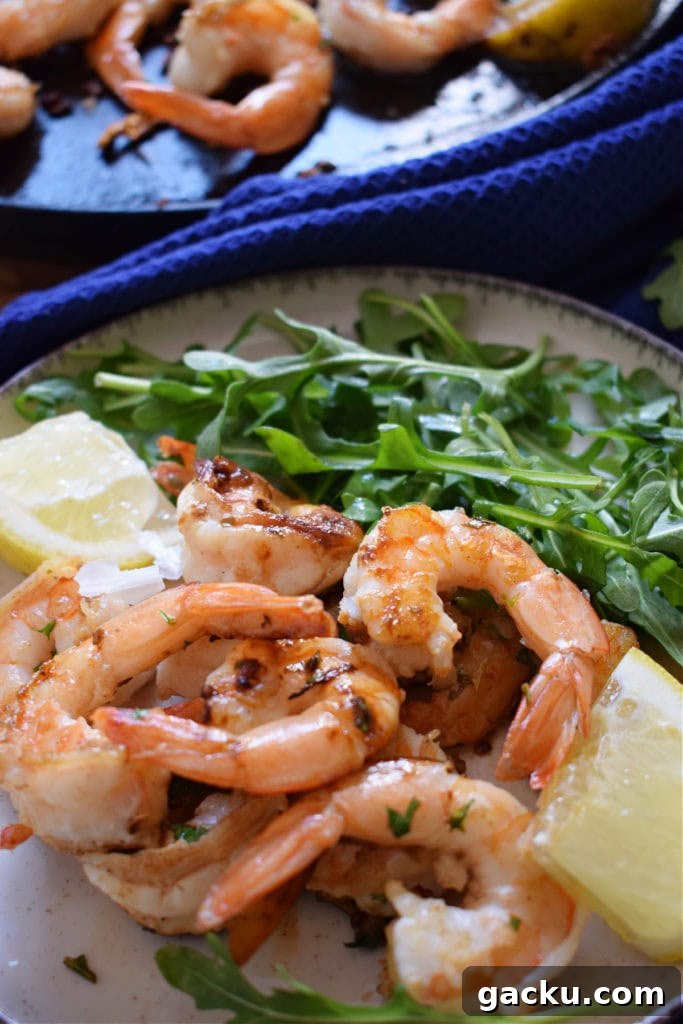 Zesty Lemon Skillet Shrimp Recipe — Quick Pan-Seared Shrimp 8 Lemon Garlic Shrimp on a plate with lemon wedges.