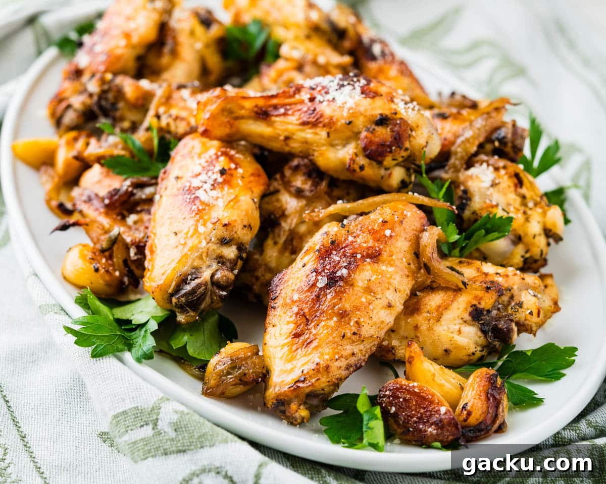 Garlic parmesan chicken wings on a white platter.