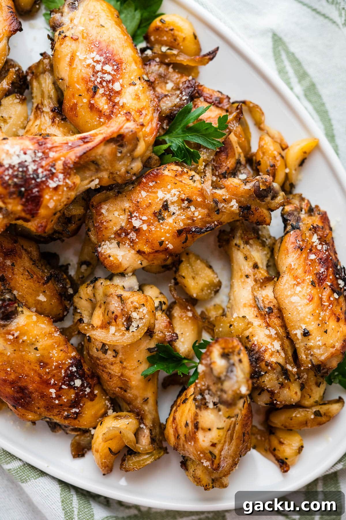 Garlic parmesan wings on a platter with a spatter of parsley.