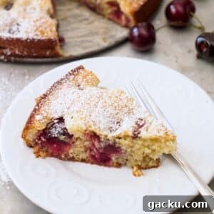 Slice of cherry almond cake on small plate.
