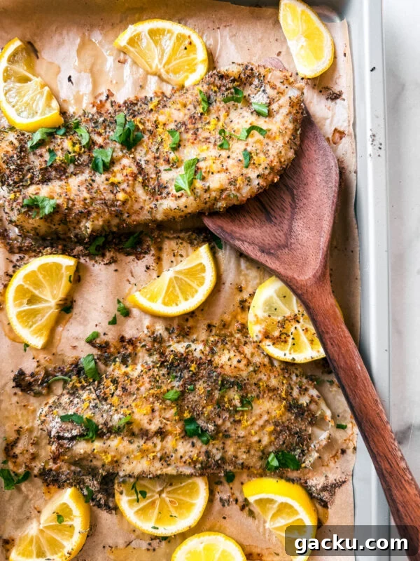 Baked lemon pepper grouper fillets on a baking dish.