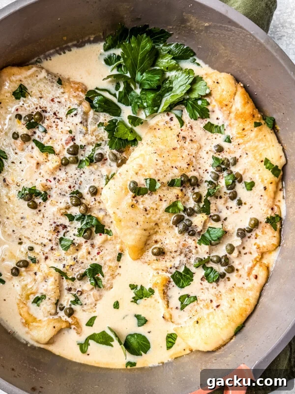 Flounder fillets in a pan smothered in creamy lemon caper sauce.