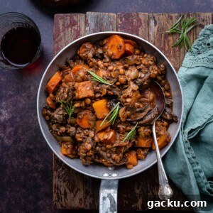 Comforting Vegan Lentil and Root Vegetable Stew 11 Vegan stew garnished with rosemary in a small pan
