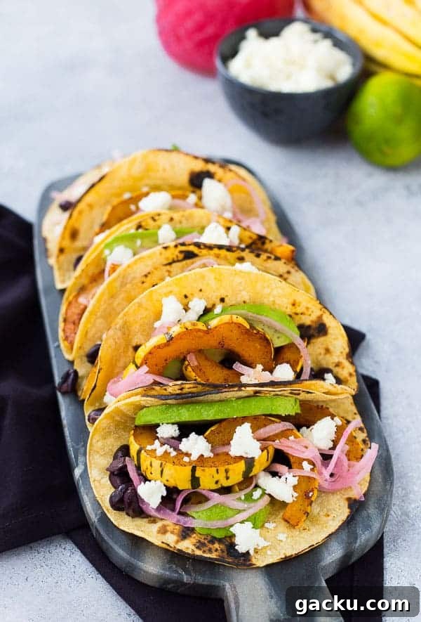Delicata Squash & Black Bean Vegetarian Tacos for Fall Flavor 3 Tacos lined up on decorative black marble.