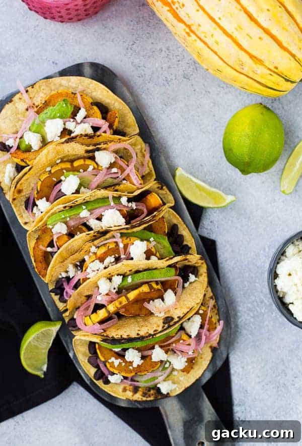 Delicata Squash & Black Bean Vegetarian Tacos for Fall Flavor 4 Overhead of tacos, with squash, limes, and cheese nearby.
