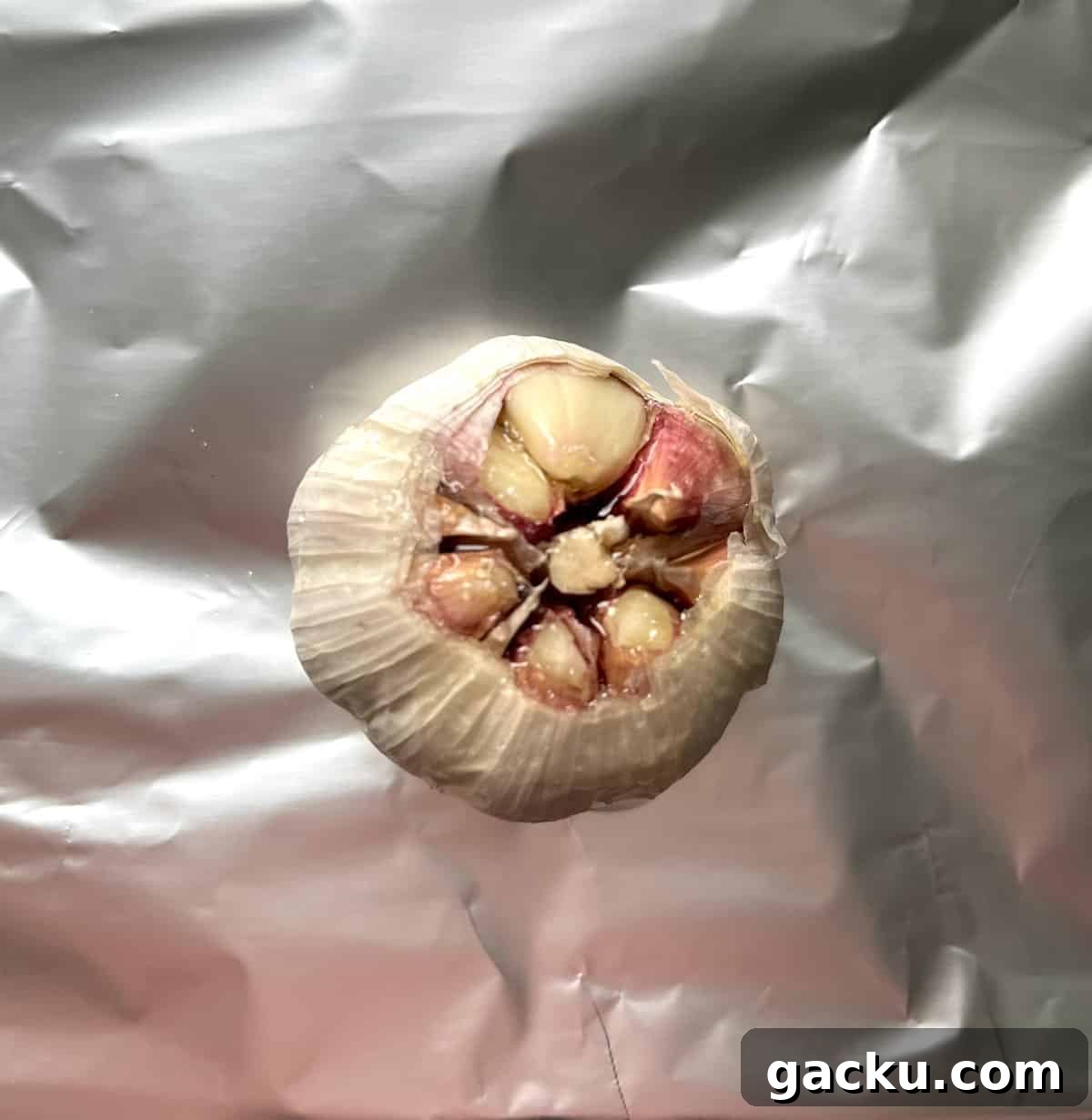 Roasted Garlic Butter Recipe for Homemade Bread, Steak & Veggies 3 A garlic head with the top sliced off to expose the cloves.