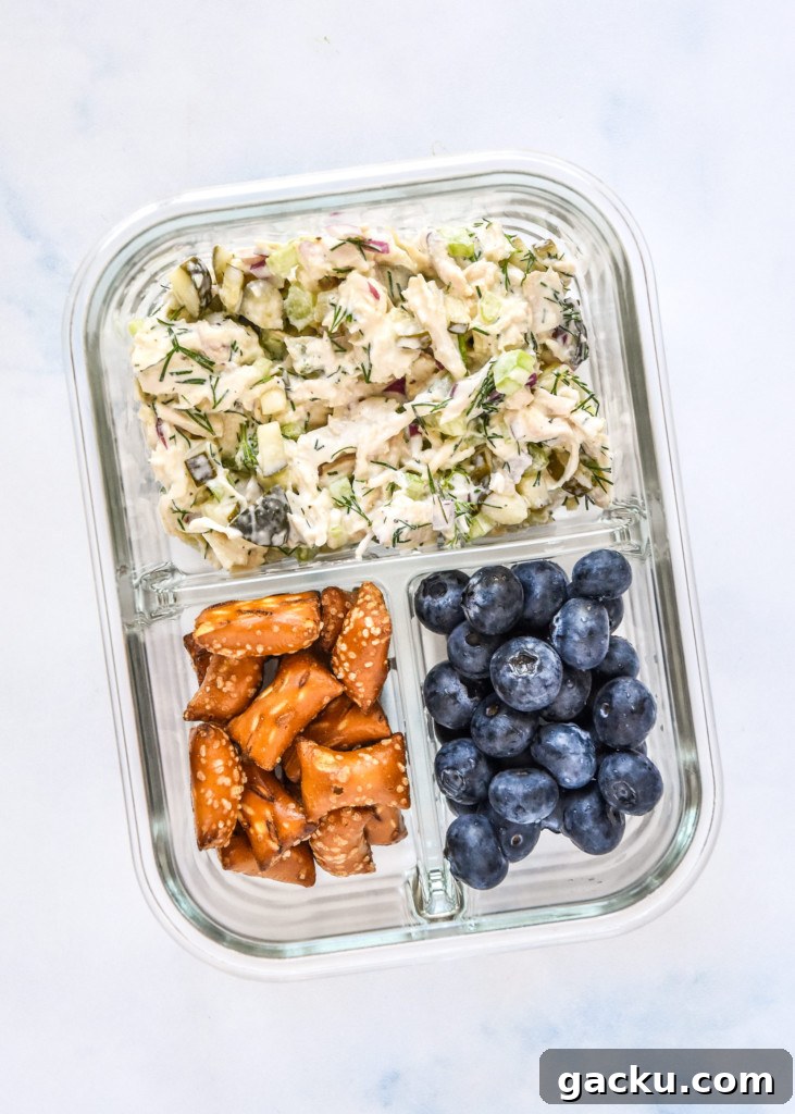 Dill Pickle Chicken Salad Recipe with Crunchy Celery & Herbs 11 dill pickle chicken salad in a meal prep container with blueberries and pretzels.