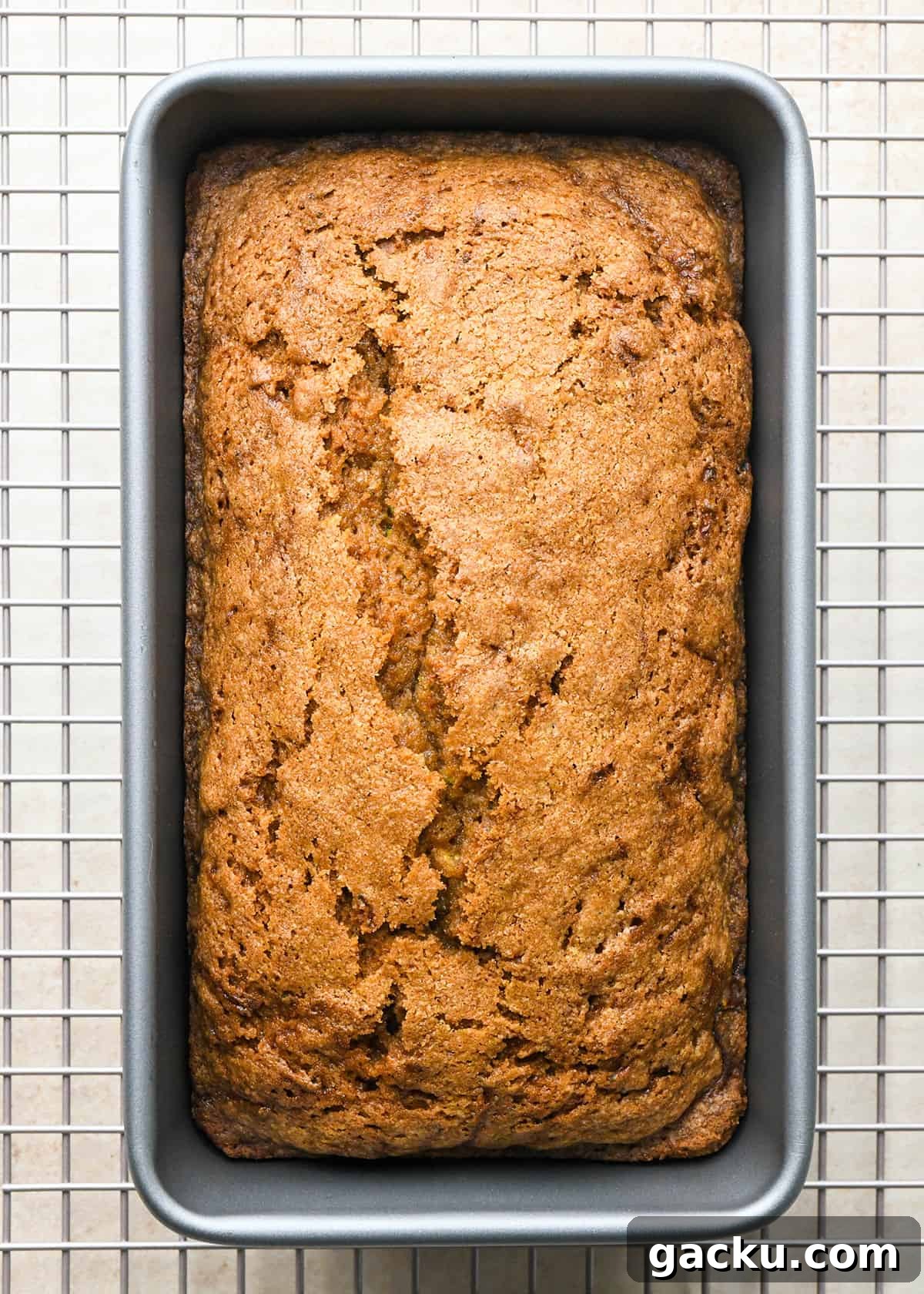 Moist Zucchini Bread Recipe That Everyone Will Love 11 baked Zucchini Bread in a loaf pan on a wire cooling rack