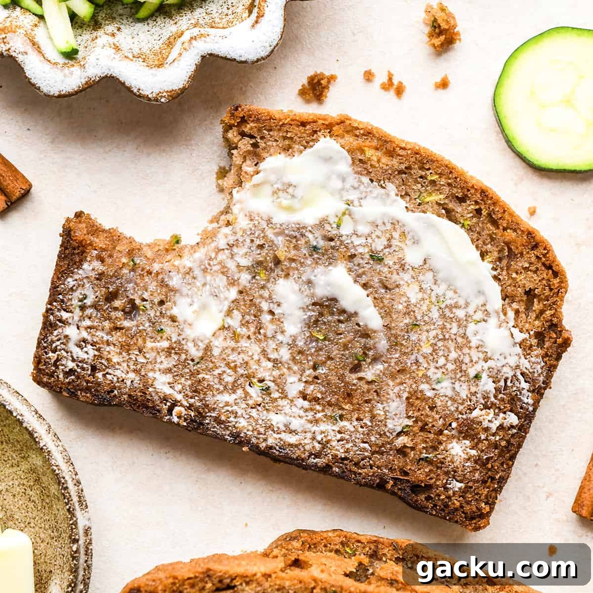 Moist Zucchini Bread Recipe That Everyone Will Love 13 a slice of Zucchini Bread with butter spread on it and a bite taken out of it