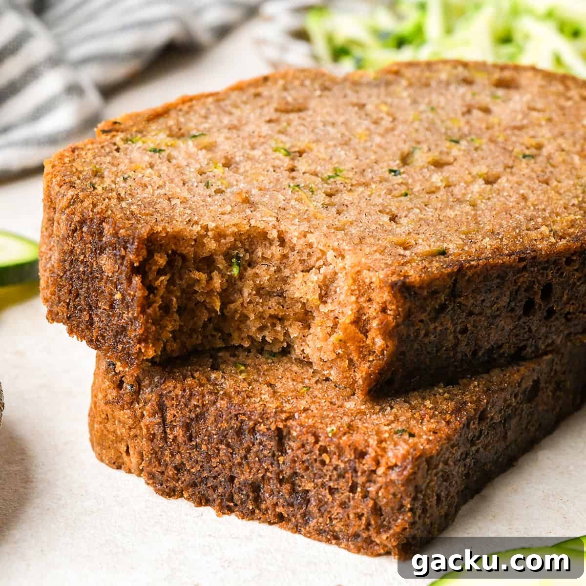 Moist Zucchini Bread Recipe That Everyone Will Love 2 a stack of 2 slices of zucchini bread, the top one with a bite taken out of it