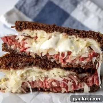 Reubens, grilled Reuben sandwich cut in half and stacked.