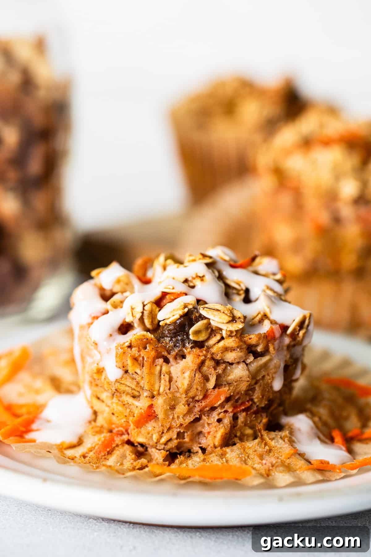 Carrot Cake Oatmeal Muffins: Spiced Breakfast Cups with Raisins and Nuts 5 Carrot granola muffins on a white plate.