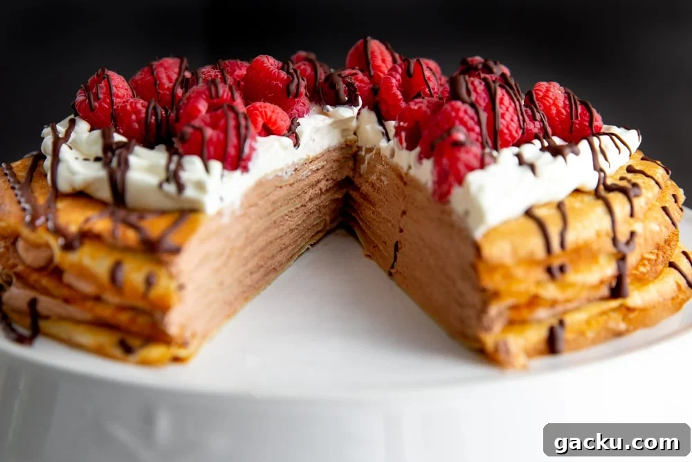 Crepe cake on a cake stand with a slice cut out.