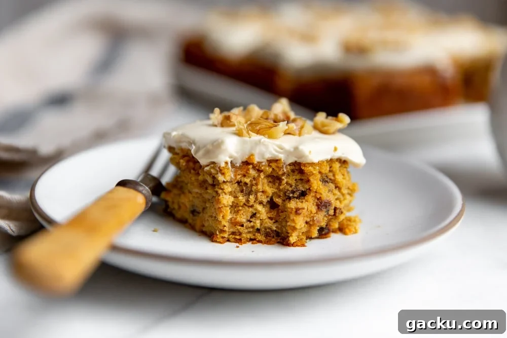 Slice of gluten free carrot cake on a plate with a fork.