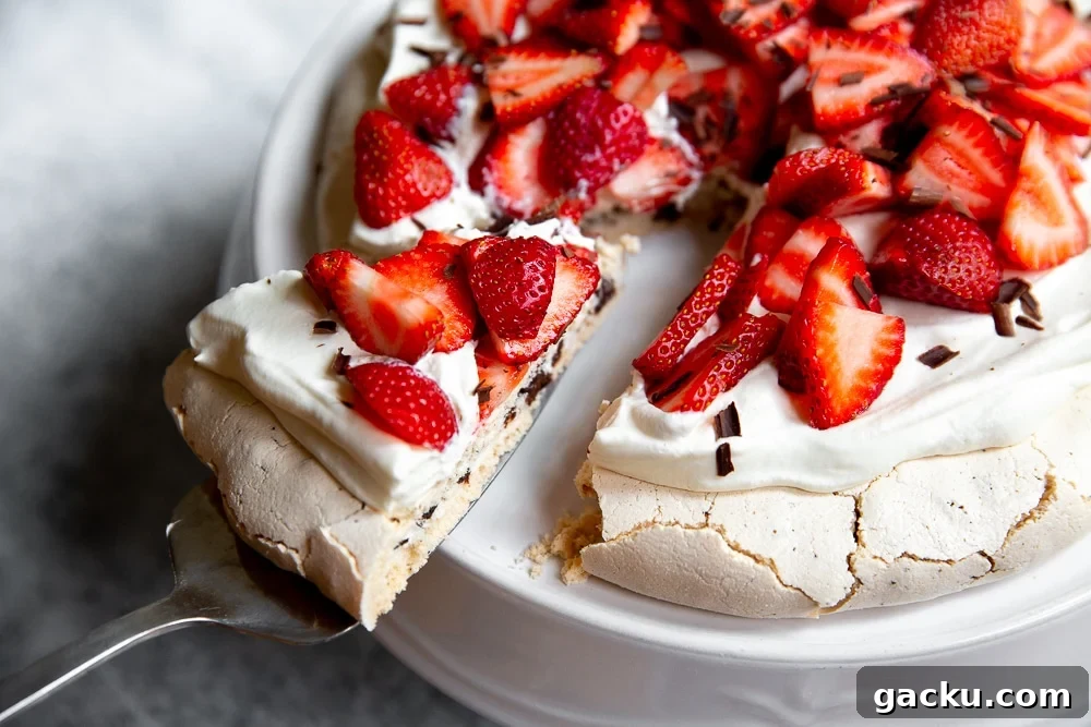 A slice of pavlova topped with whipped cream and strawberries.