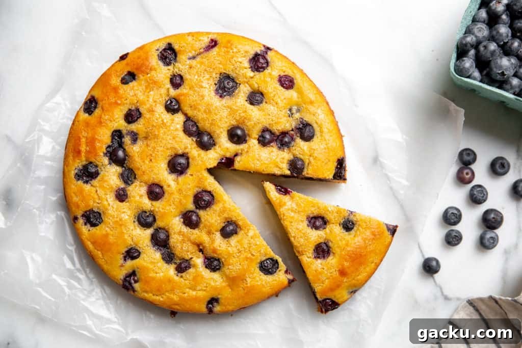 A gluten free blueberry yogurt cake on a marble surface.