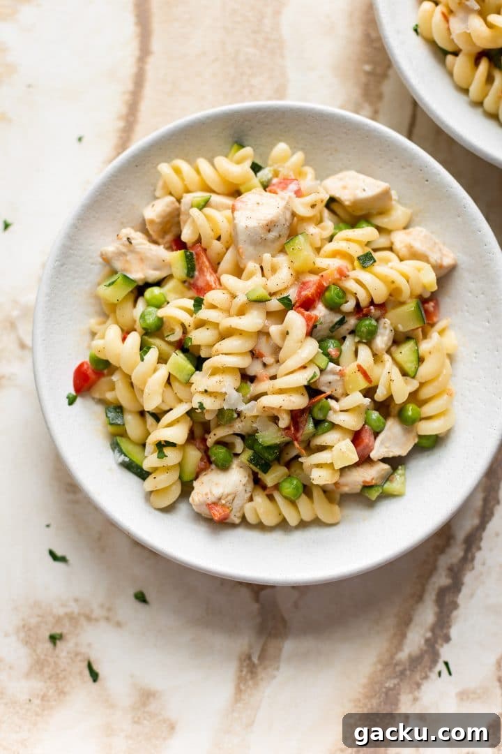 pasta with vegetables and chicken in a white bowl