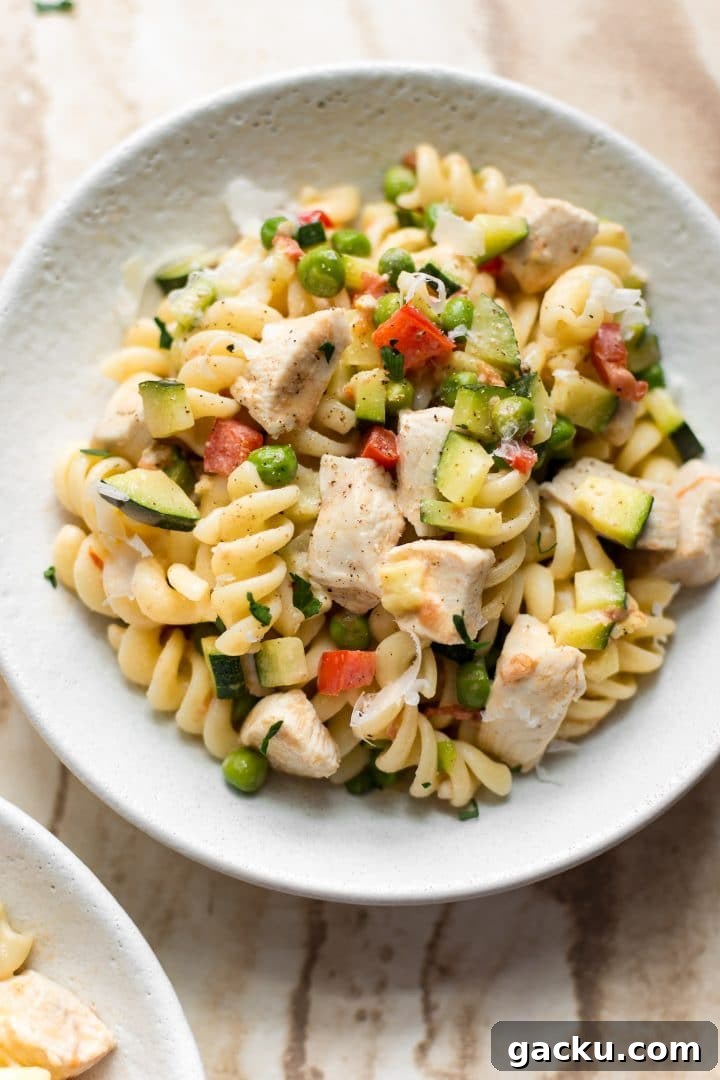 close-up of chicken pasta primavera in a white bowl
