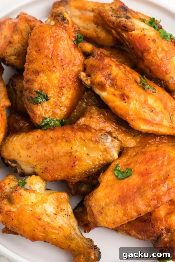 Crispy Air Fryer chicken wings on a white plate ready to serve.