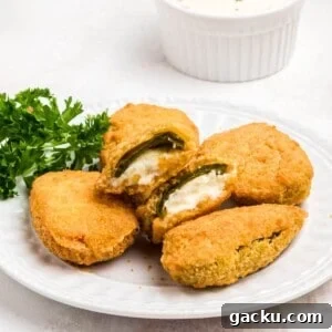 Golden crispy breaded jalapeno poppers on a small white plate.