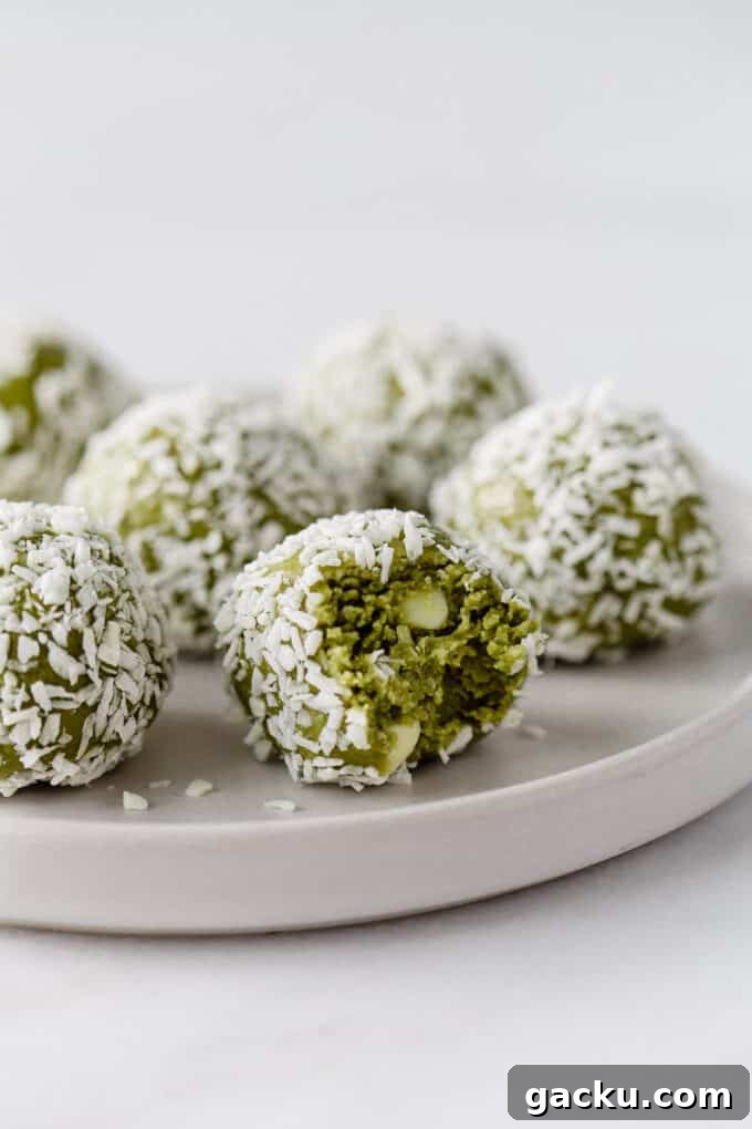 Energizing Matcha Energy Bites for Sustained Focus 2 matcha balls coated in coconut on a white plate