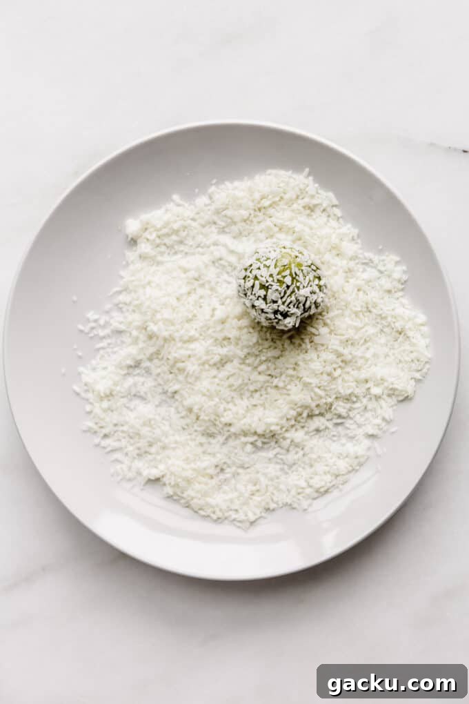 Energizing Matcha Energy Bites for Sustained Focus 7 a matcha energy ball in a plate of shredded coconut
