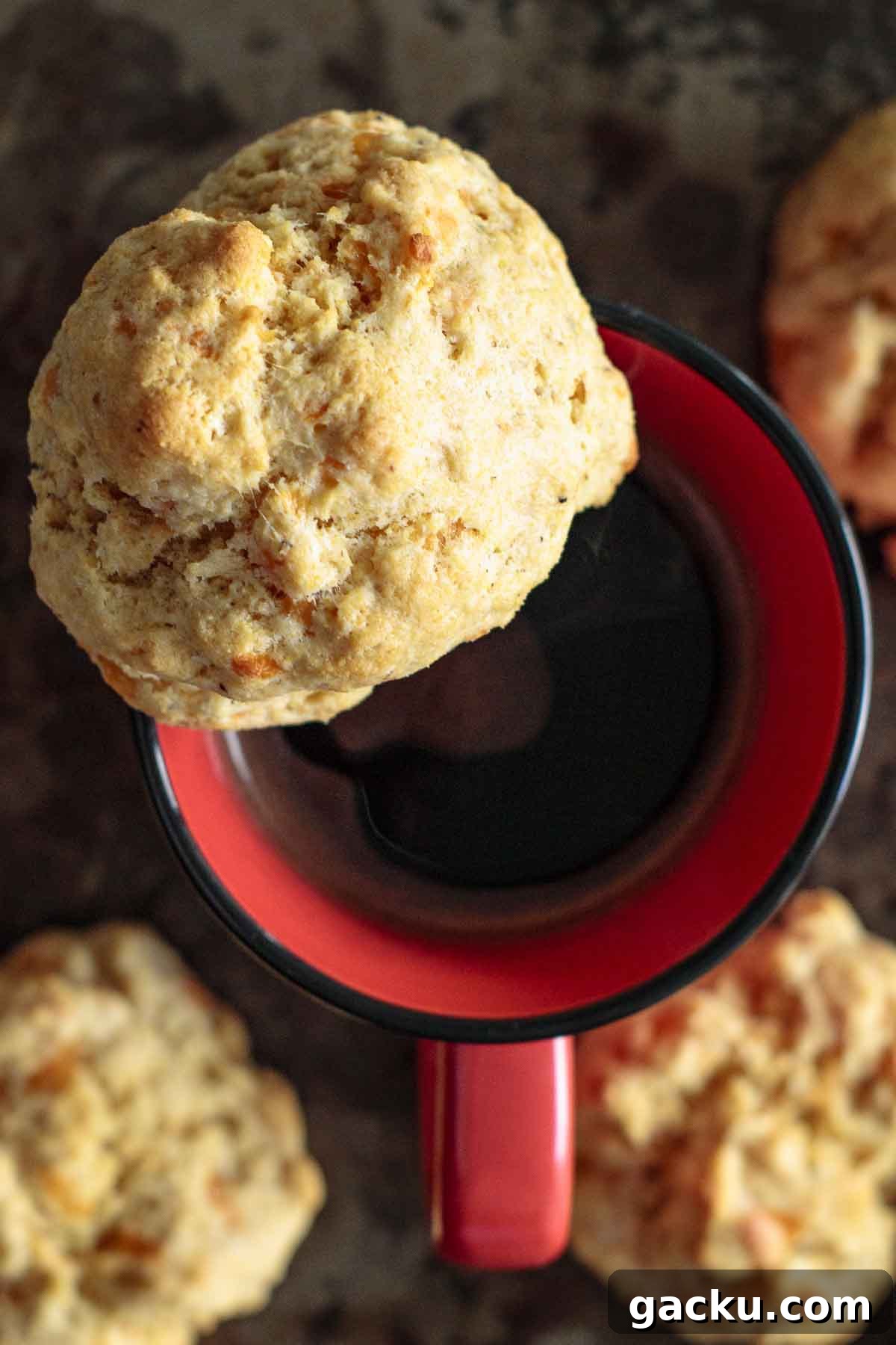 Cornmeal Drop Biscuits Without Buttermilk — Quick Southern Recipe 3 A biscuit over a red coffee mug.
