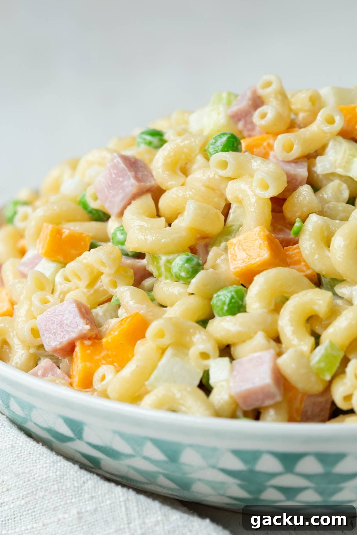 Cheesy Ham Macaroni Salad with Sharp Cheddar 2 creamy macaroni salad with ham, peas, and cheddar cheese cubes.