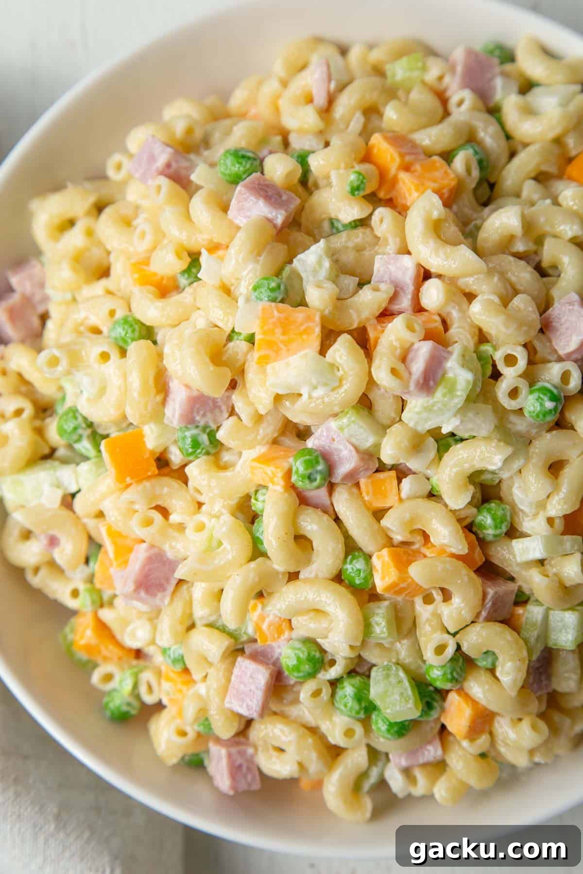 Cheesy Ham Macaroni Salad with Sharp Cheddar 7 big bowl of creamy macaroni salad with ham, peas, and cheddar.
