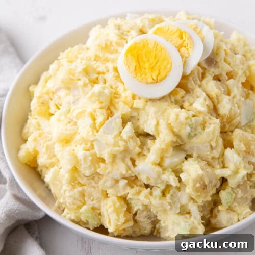 grandma's potato salad in a bowl topped with slices of hard boiled eggs.