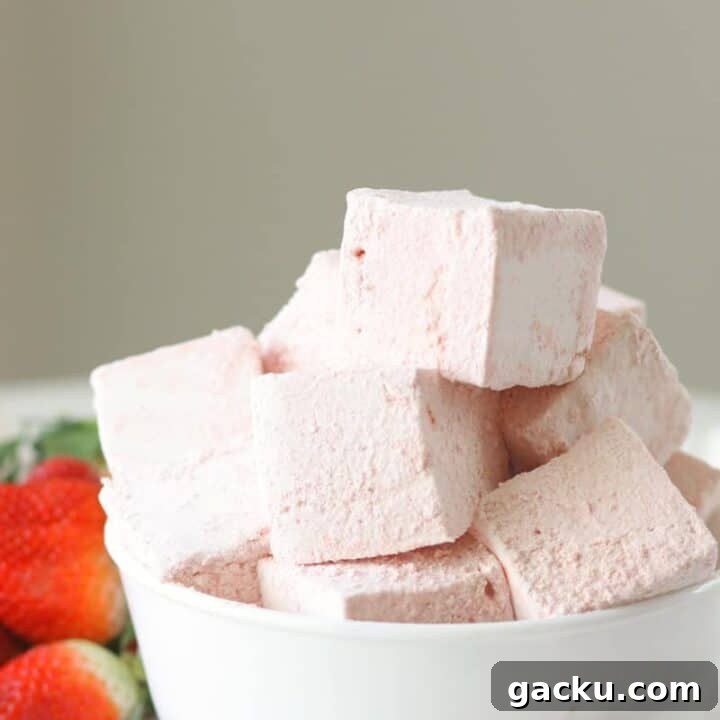 a bowl of strawberry marshmallows with fresh strawberries