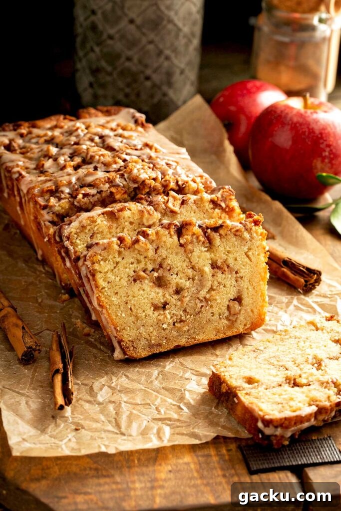 Cinnamon Apple Quick Bread Recipe for Moist, Spiced Loaf 2 Partially sliced homemade apple quick bread with cinnamon sugar streusel and glaze