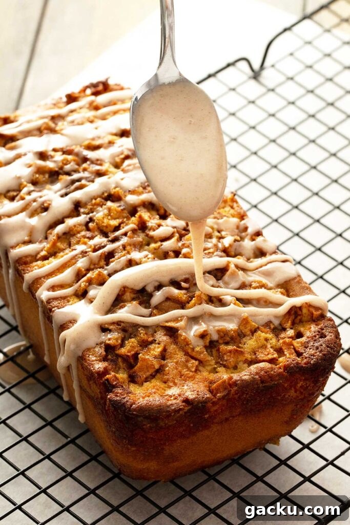 Cinnamon Apple Quick Bread Recipe for Moist, Spiced Loaf 8 A spoon drizzling cinnamon glaze over apple loaf